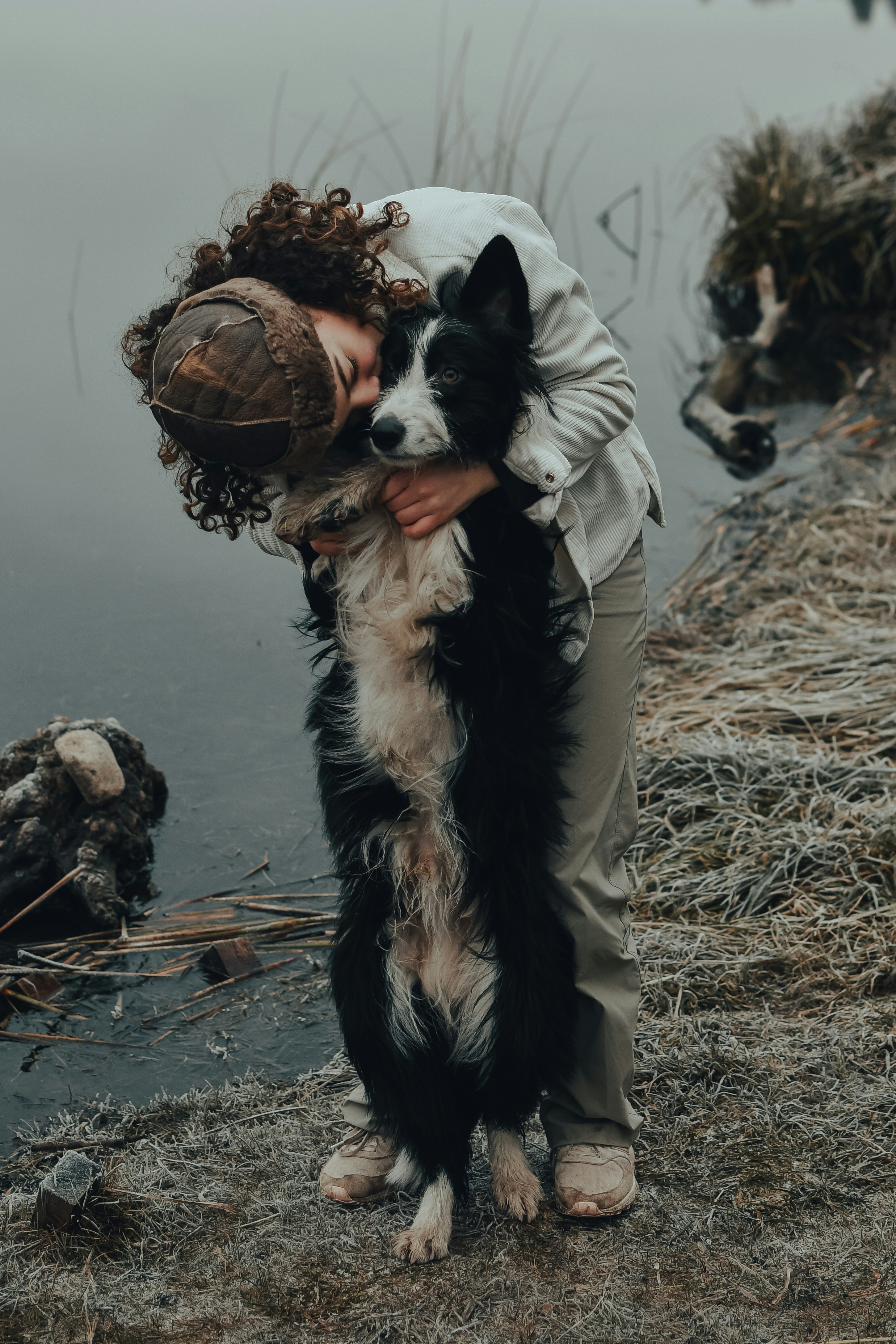 A girl standing with a black&white dog